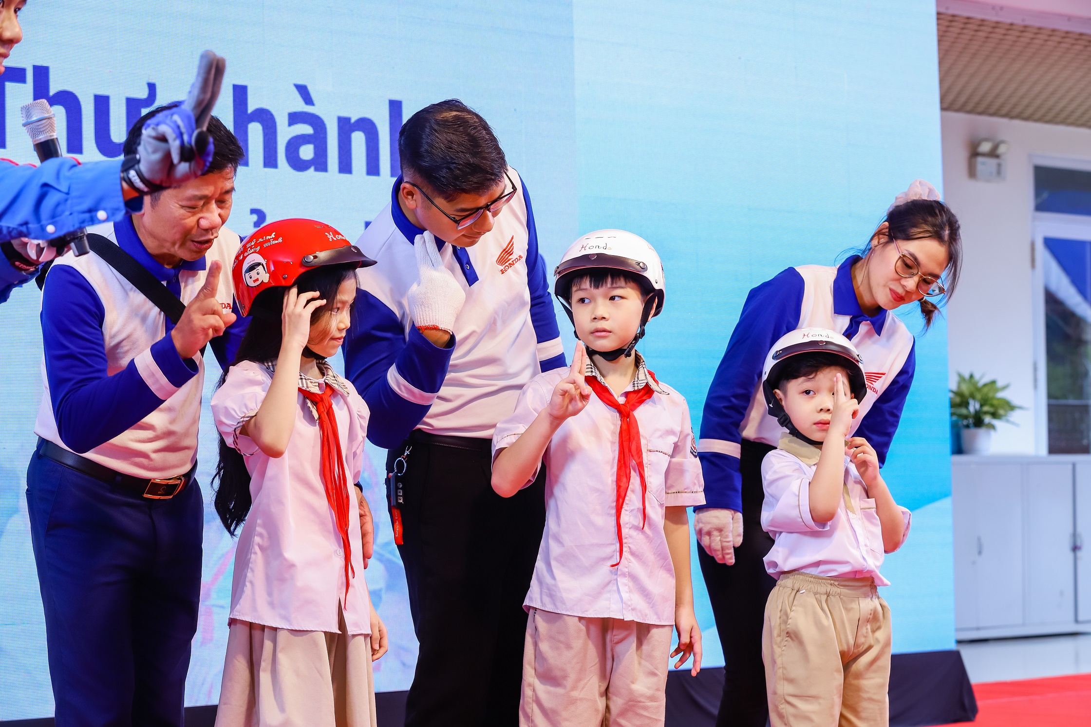 Trao tặng mũ bảo hiểm cho học sinh lớp Một kết hợp đào tạo kiến thức an toàn giao thông cho họ...JPG